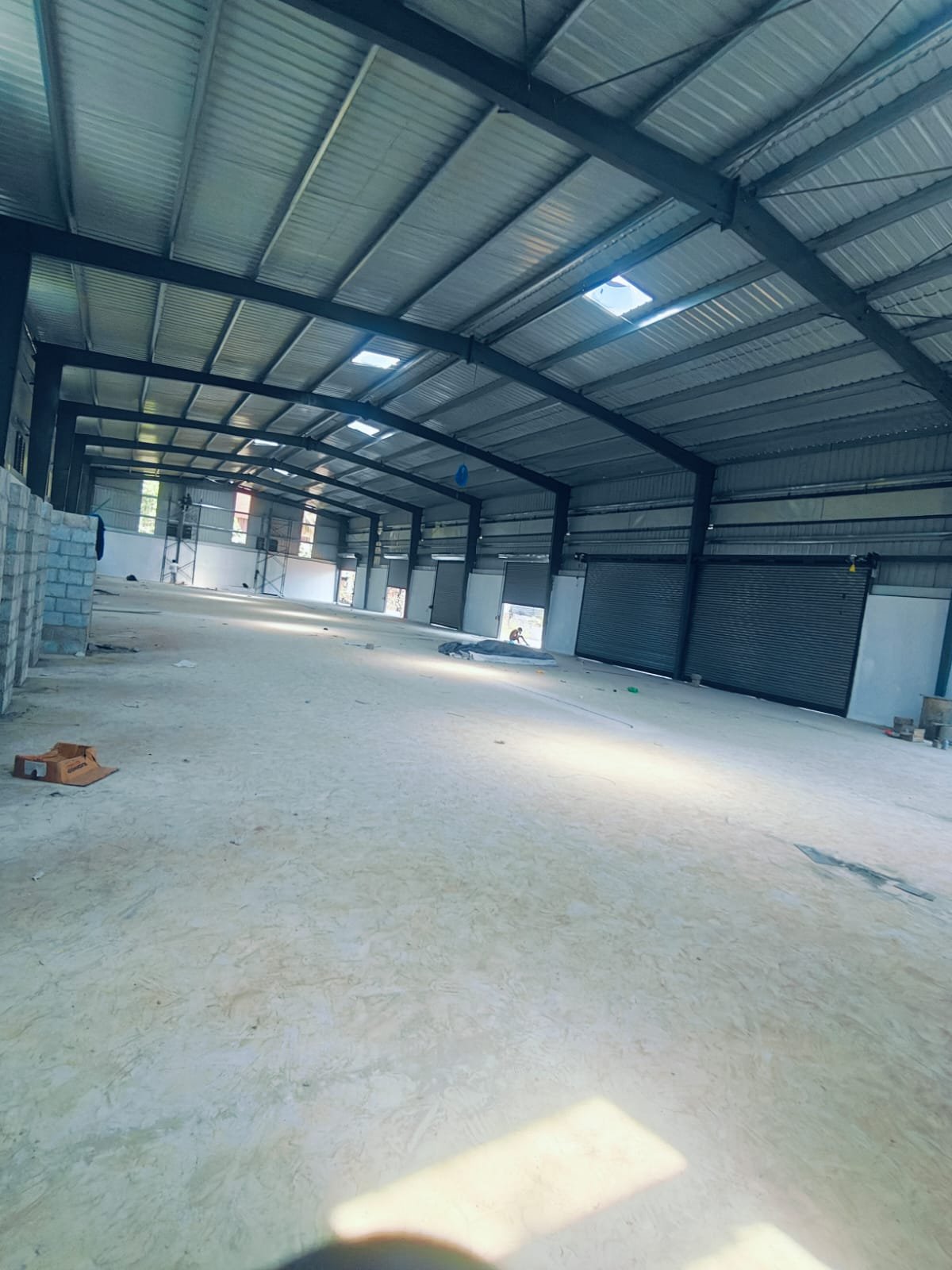 Interior of a PEB steel warehouse with roof sheeting and shutters built by an industrial construction company in Kerala