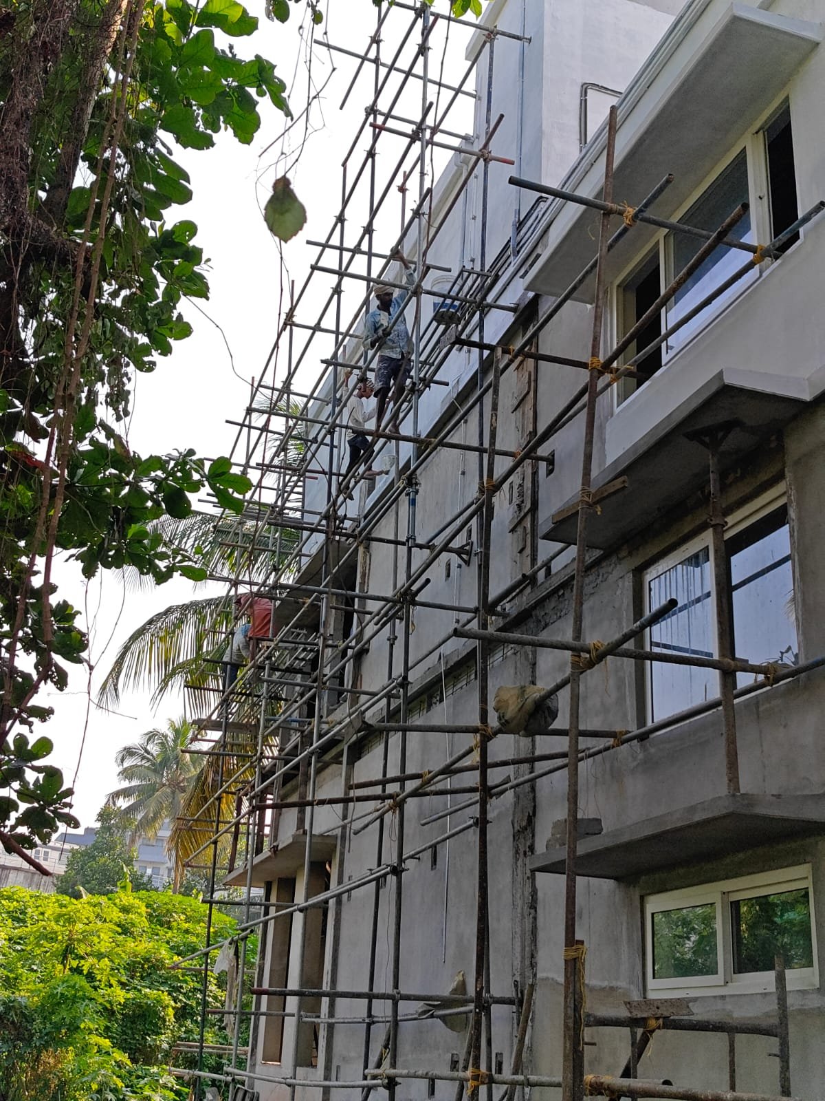 Plastering and structural work in progress on a multi-storey building in Kerala
